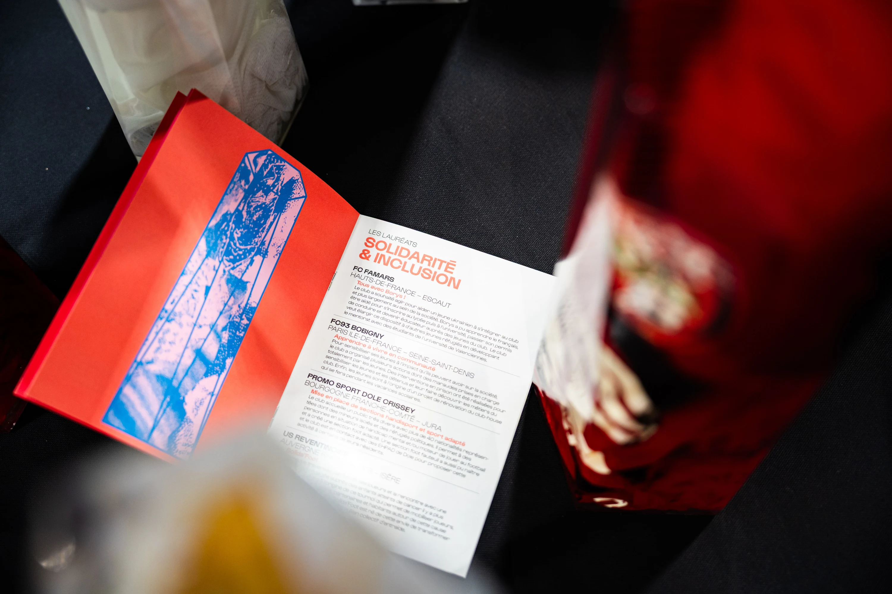 Le livret de la Fondaction du Football ouvert sur la table des trophées