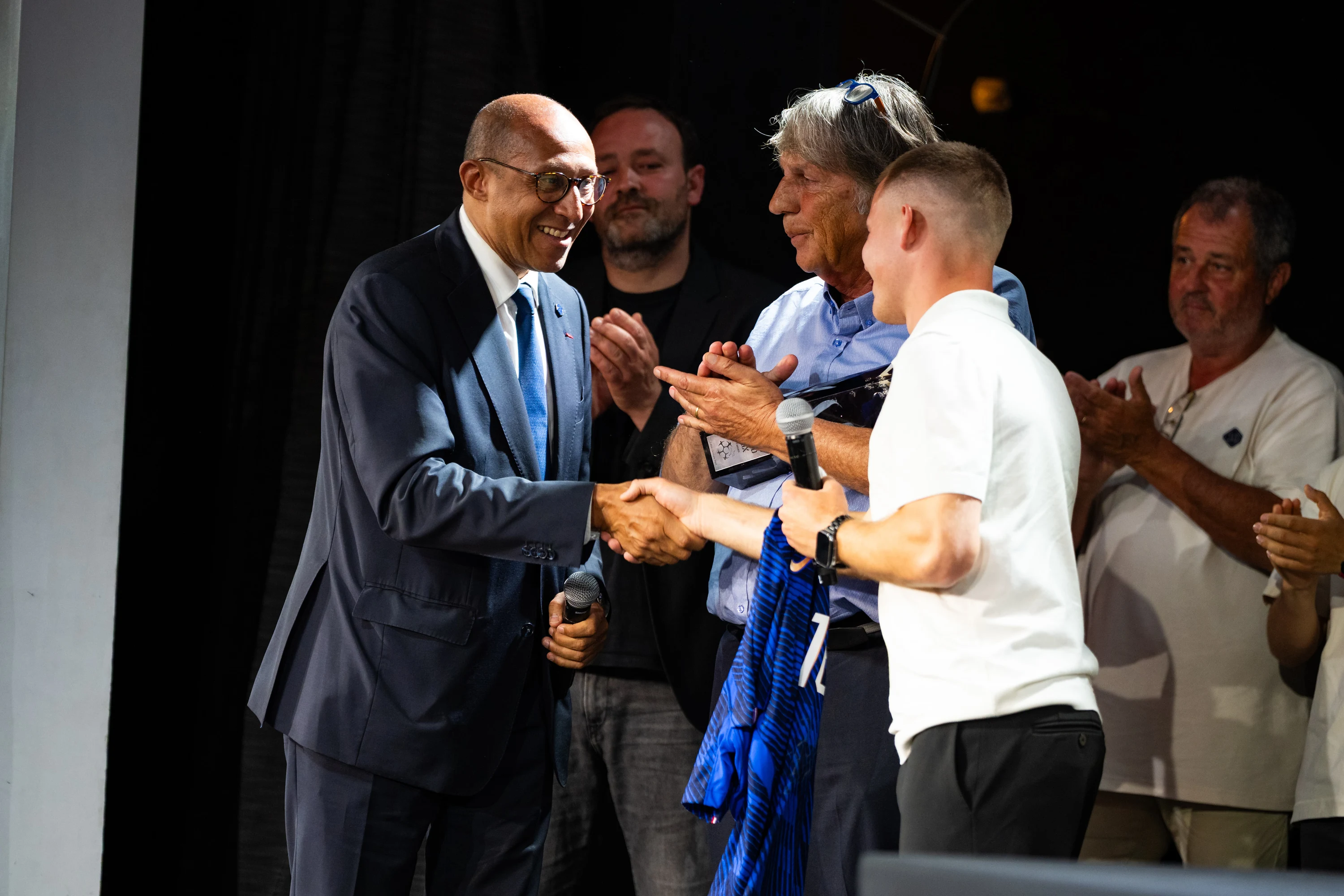 Poignée de main sur scène au moment de la remise d'un trophée