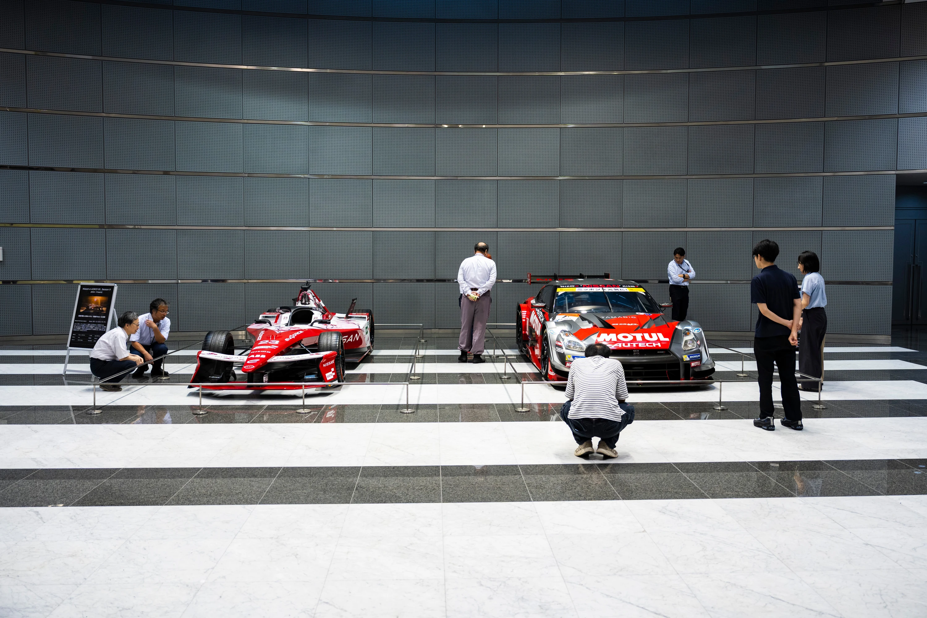 Deux voitures de course Nissan exposées dans le hall du siège de la marque