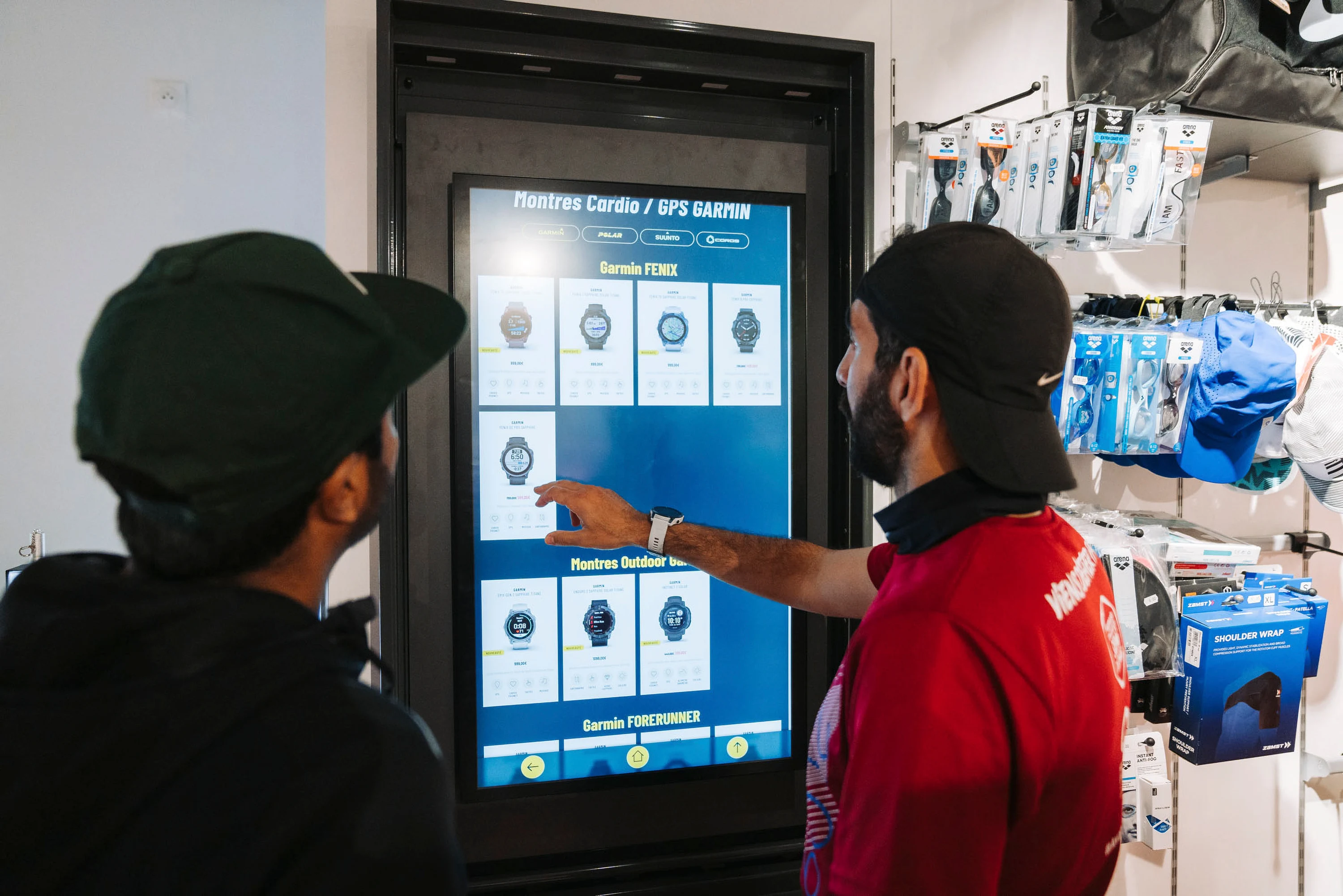Un vendeur présente la gamme de montres GPS sur la borne tactile du magasin