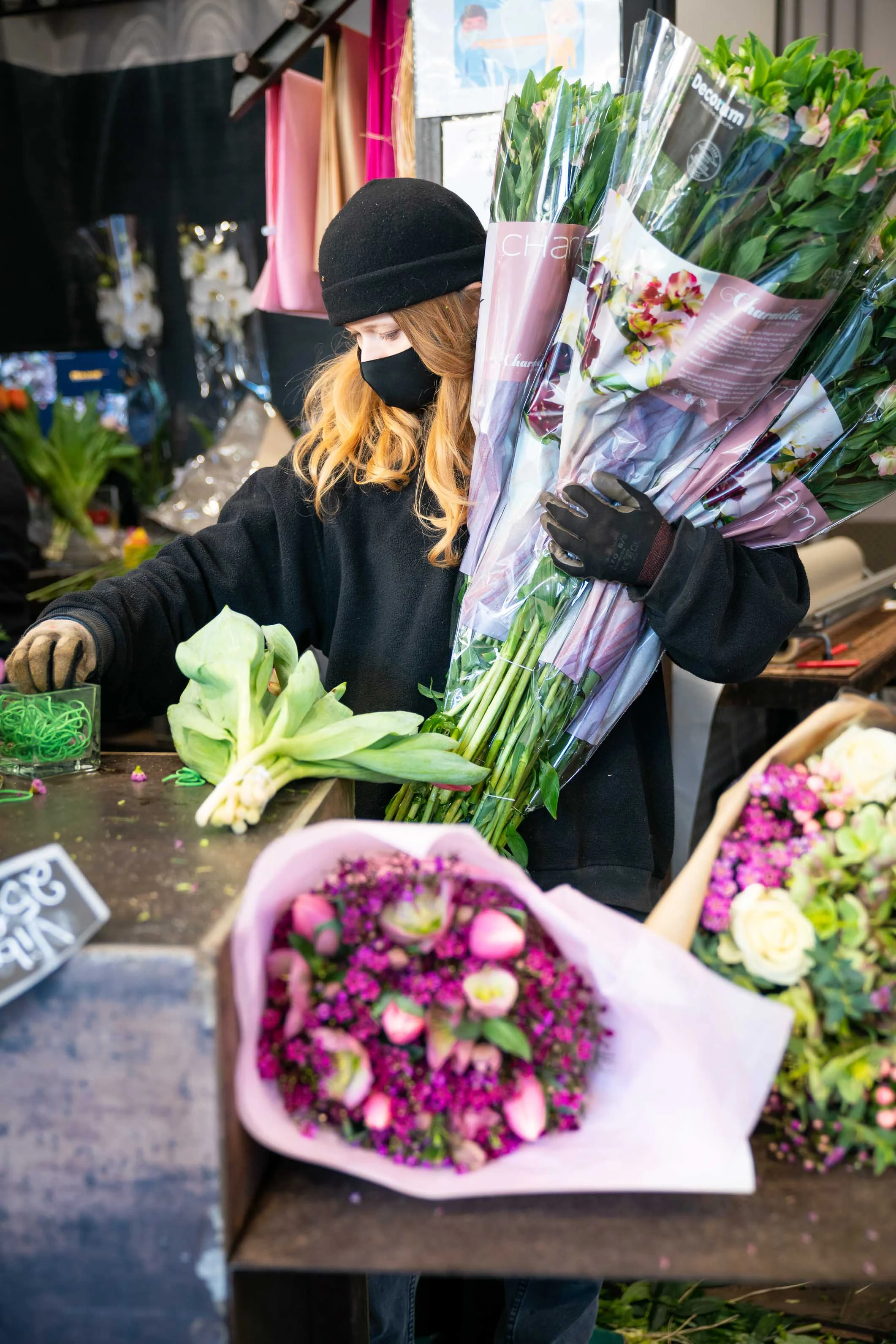Une fleuriste prépare un bouquet sur son stand