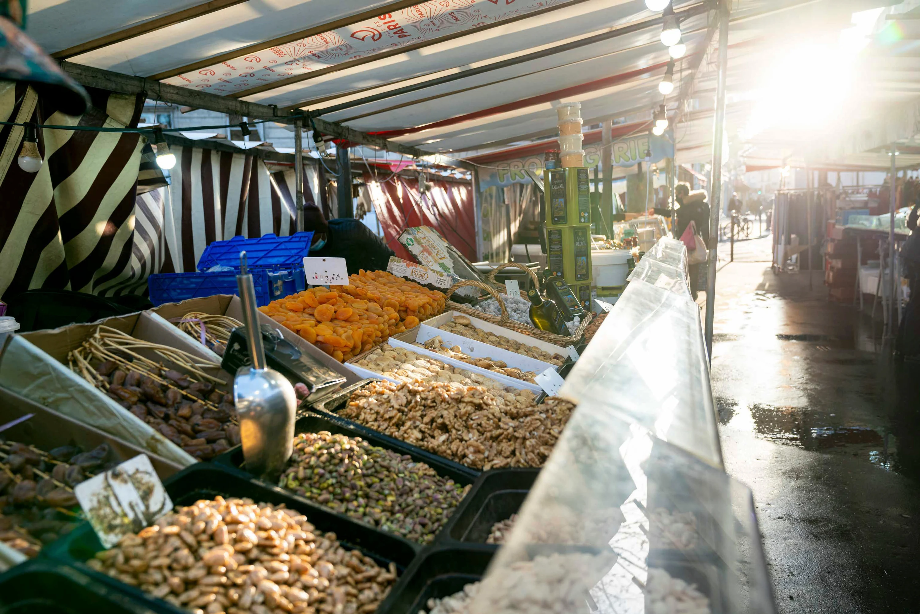 L'allée du marché à contre-jour, un étal de fruits secs au premier plan