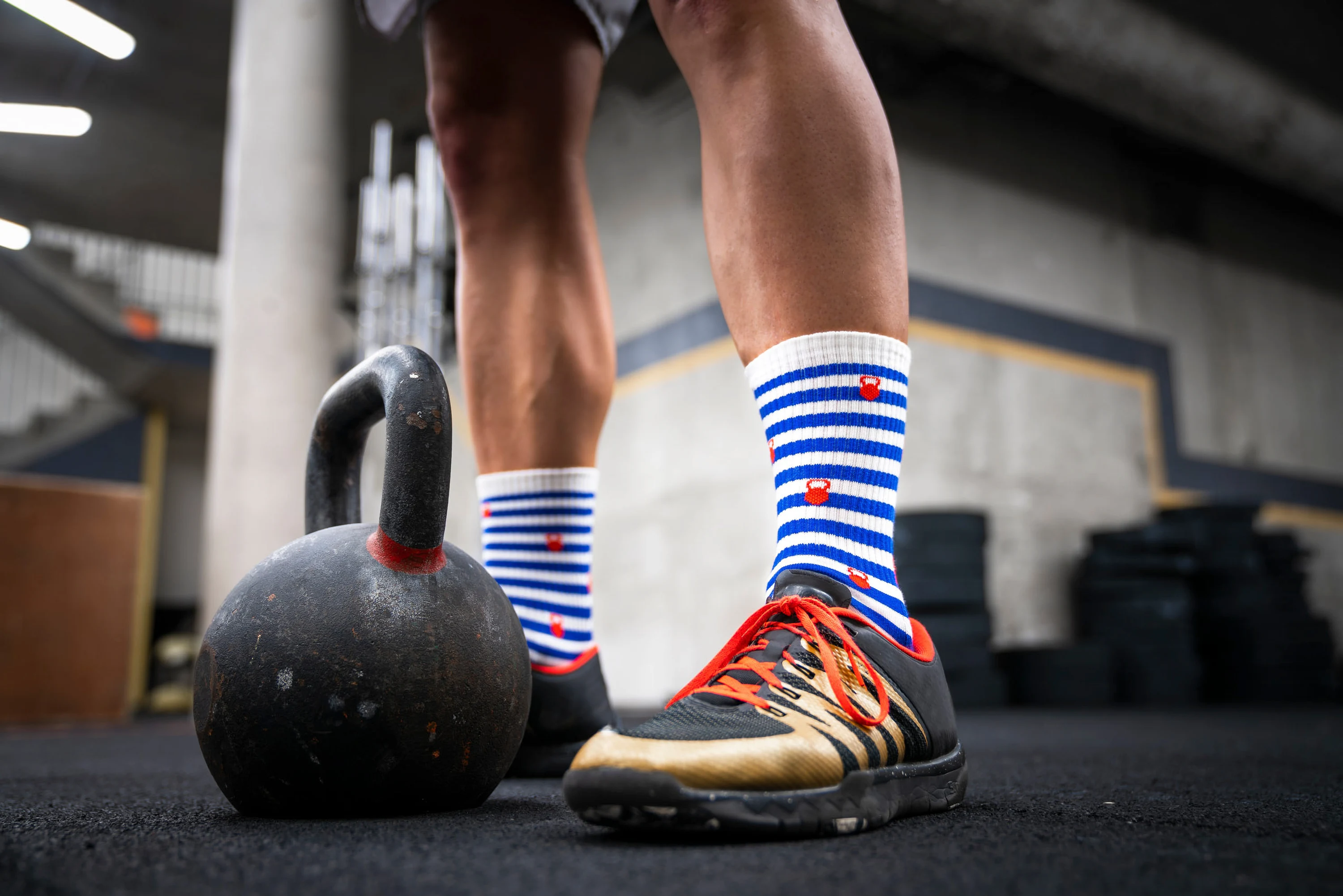 Gros plan sur une chaussette rayée à côté d'une kettlebell
