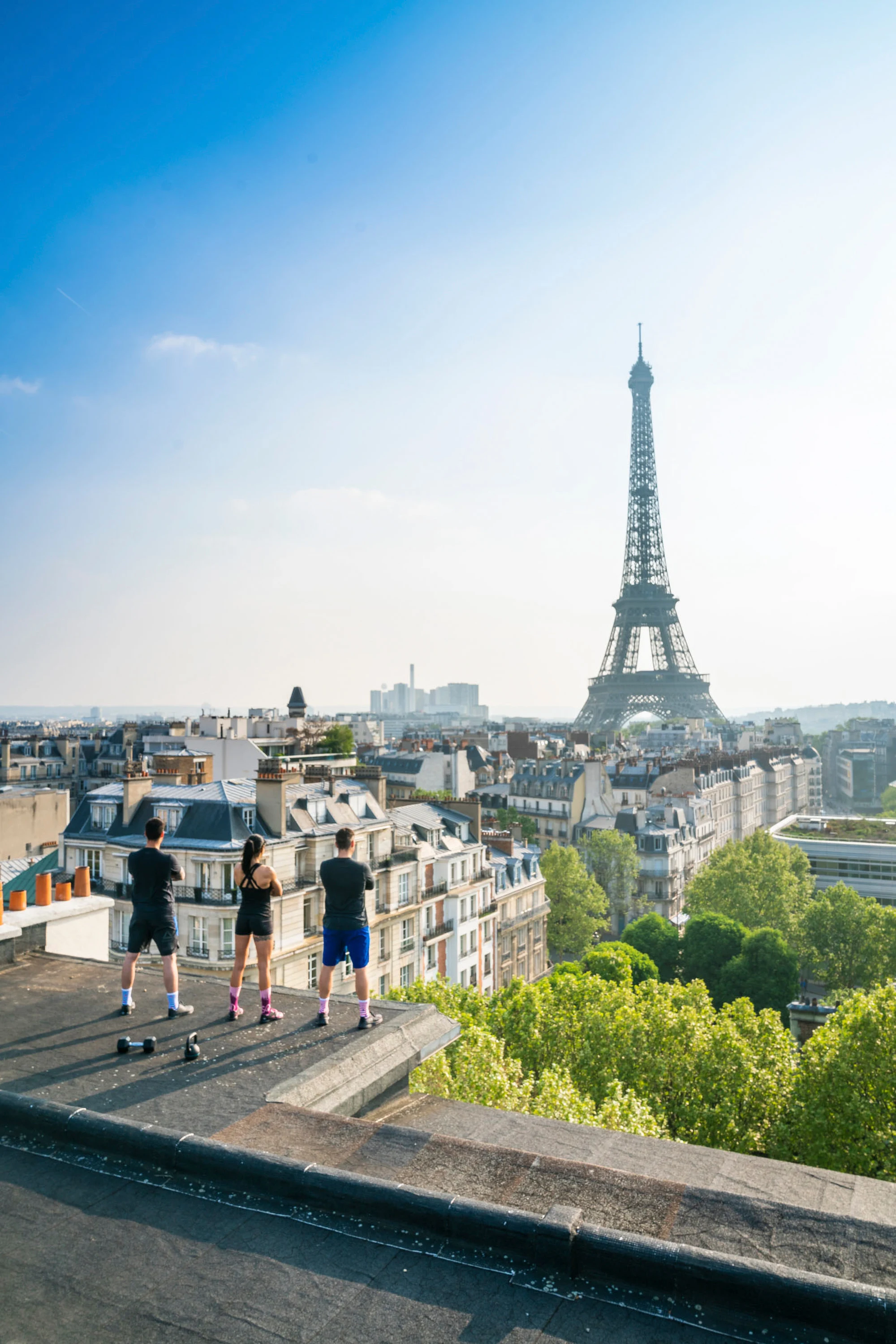 Les toits parisiens et la tour Eiffel, trois silhouettes sur la terrasse