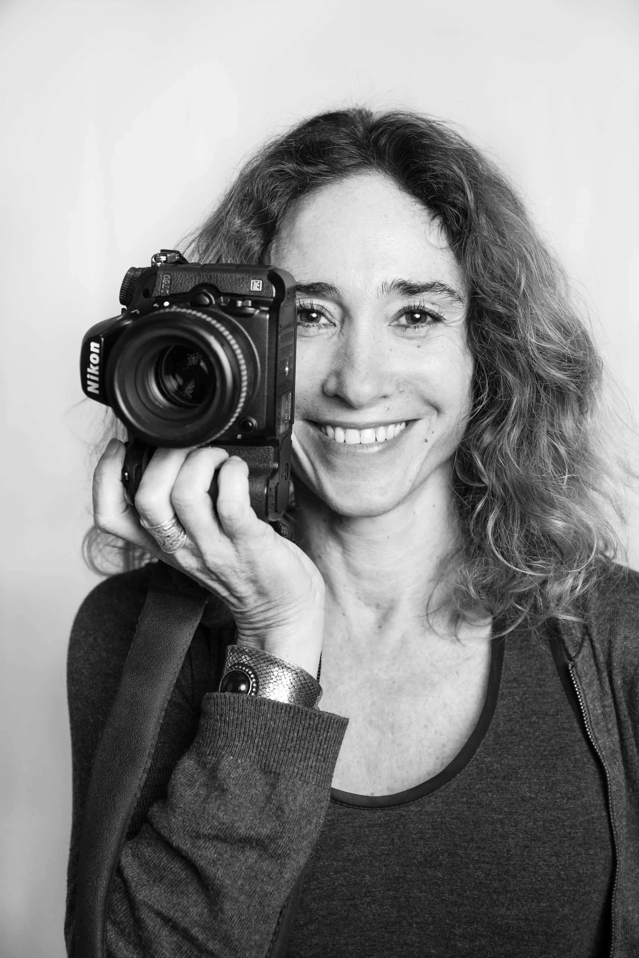 Portrait en studio d'une photographe, son boîtier devant elle