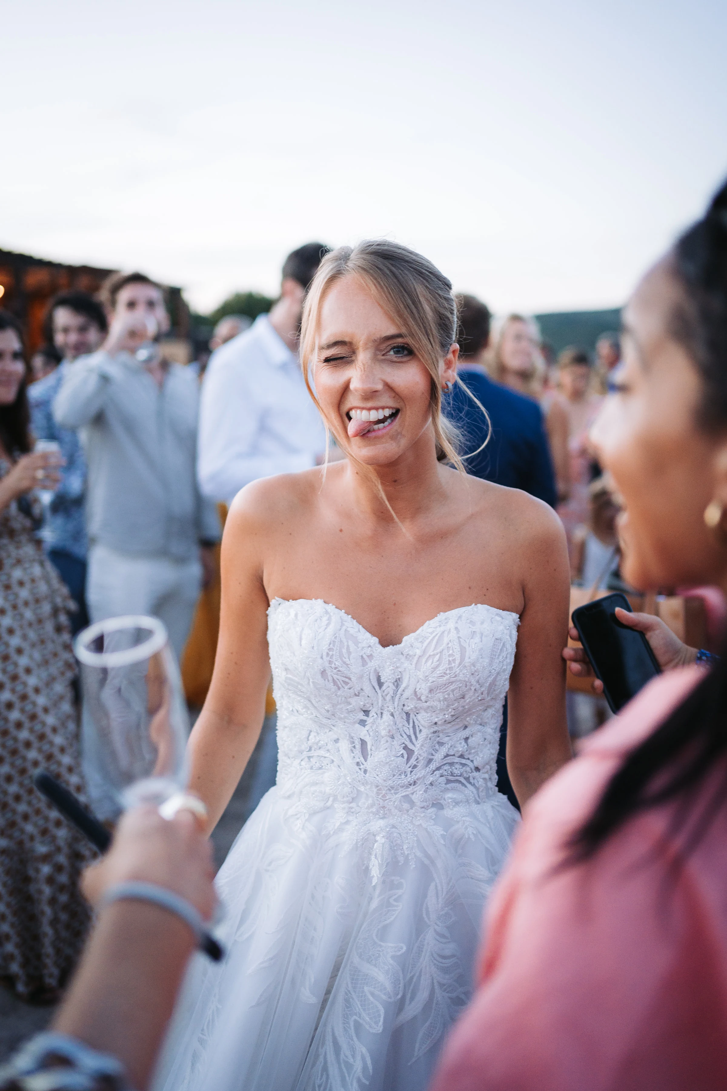 Une mariée éclate de rire au milieu de ses invités pendant le cocktail