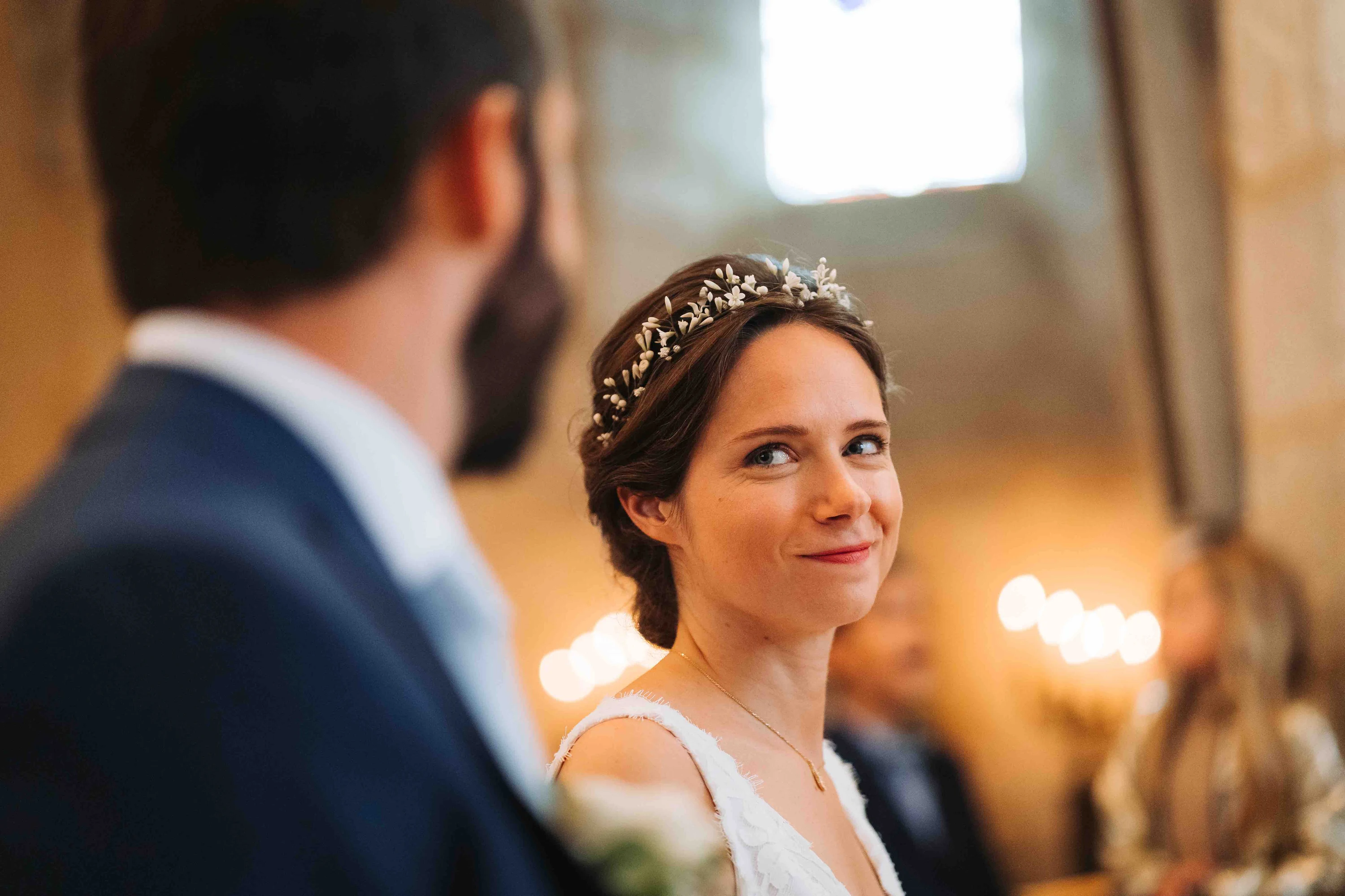 Une mariée regarde le marié pendant la cérémonie, à la lueur des bougies