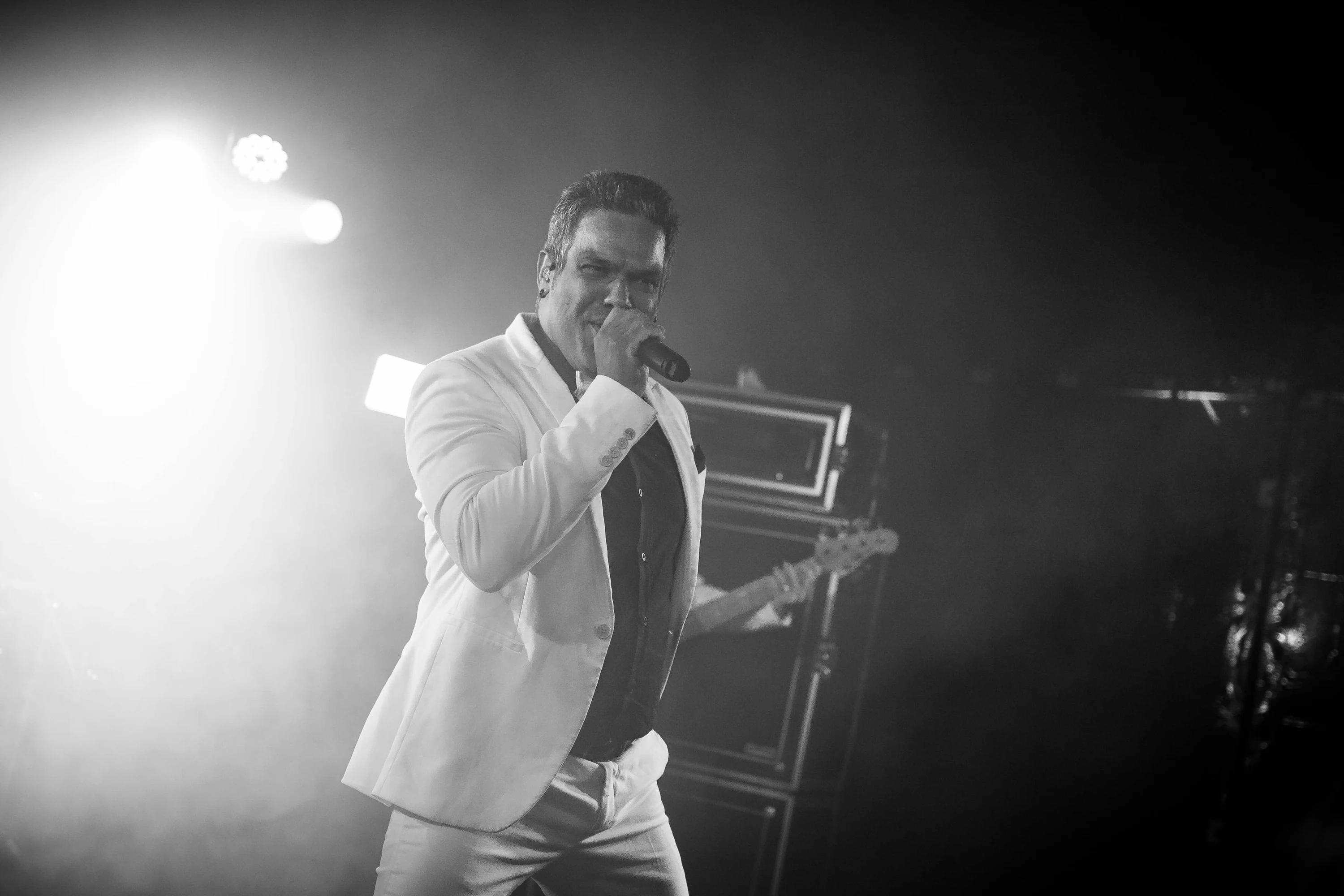 Noir et blanc : le chanteur du groupe saisi dans les projecteurs pendant la soirée