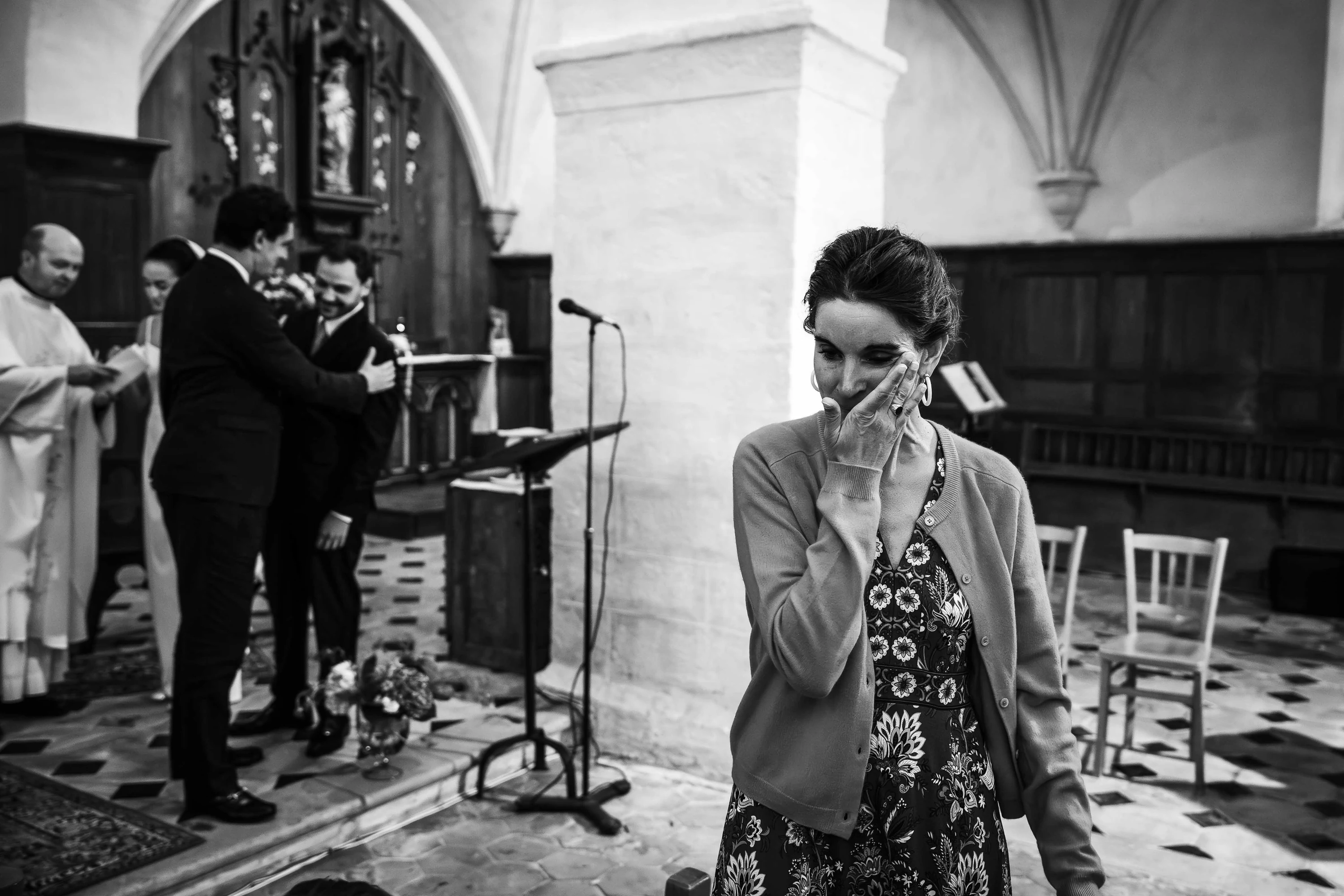 Noir et blanc : une proche essuie une larme pendant la cérémonie à l'église
