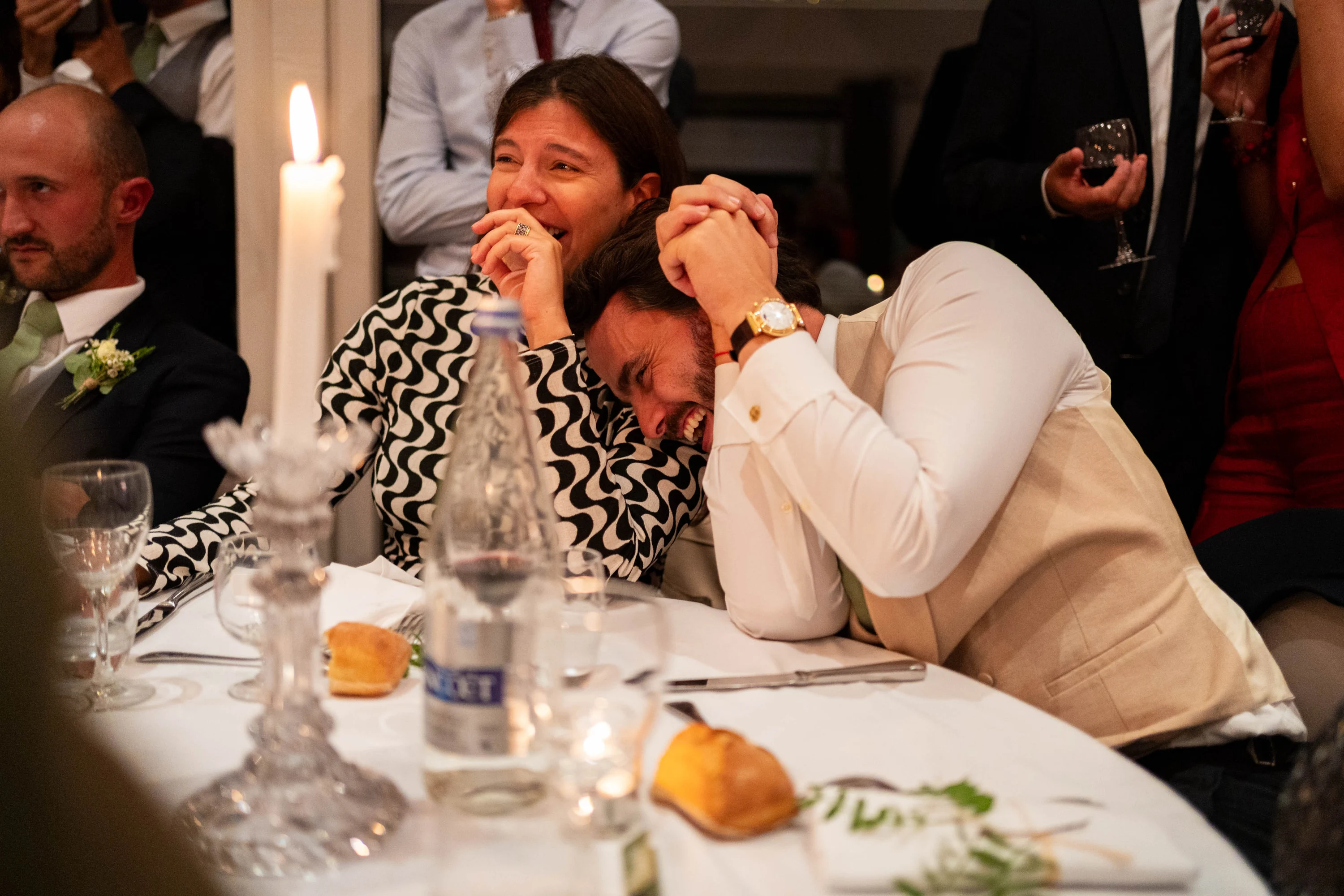 Fou rire à table pendant les discours, à la lueur des bougies