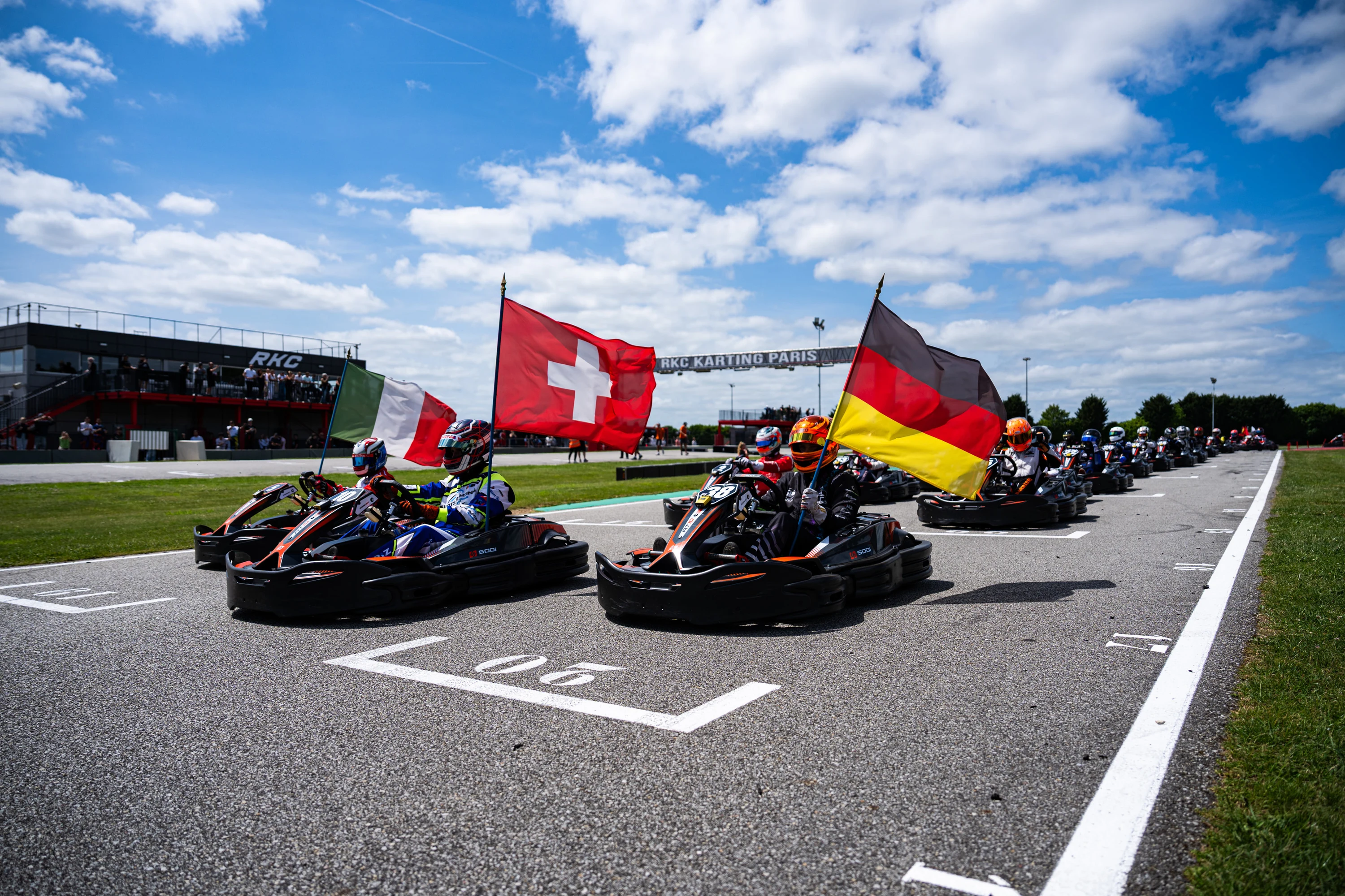 La grille de départ des 25 heures, drapeaux des nations au-dessus des karts