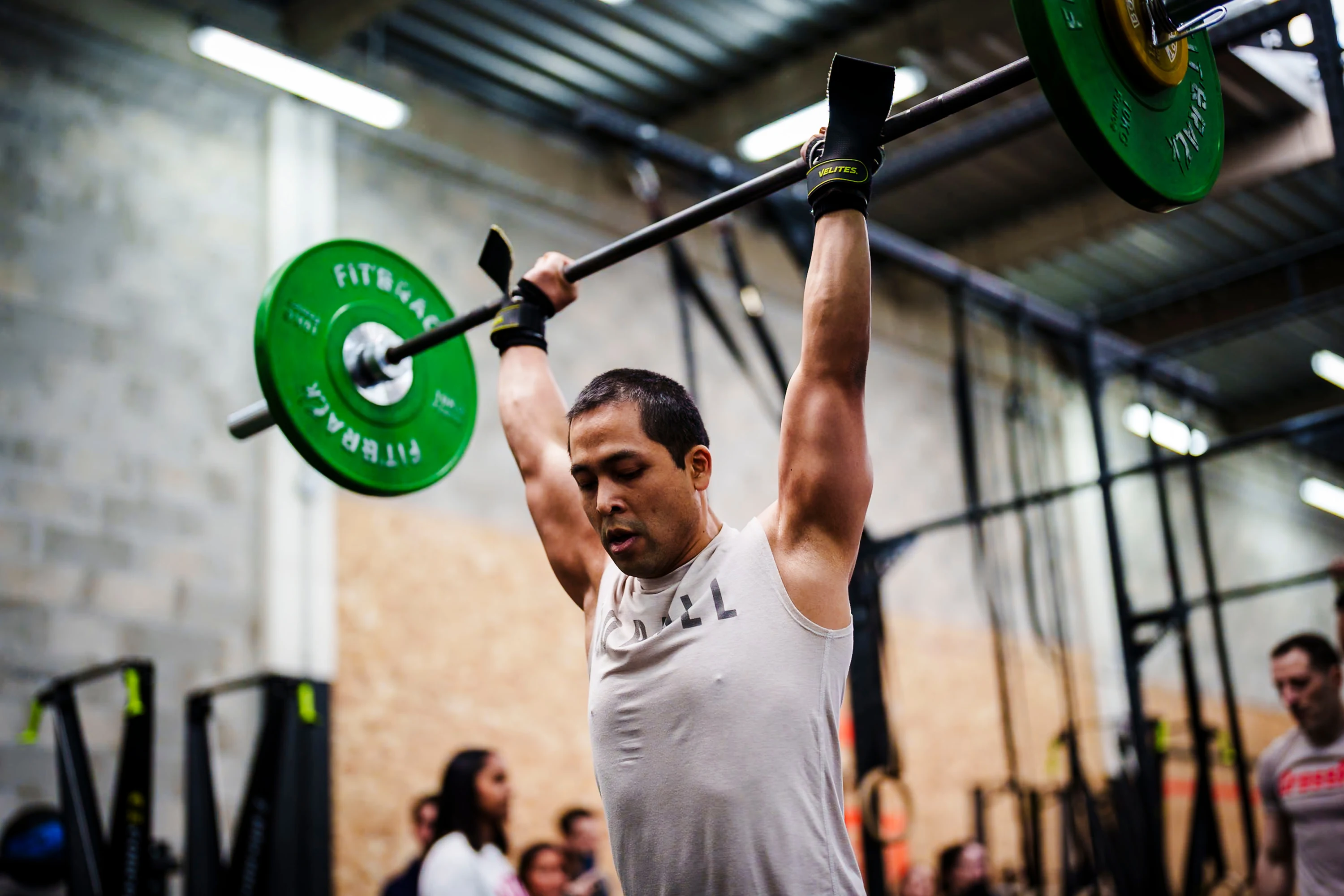 Un athlète soulève une barre au-dessus de la tête pendant l'entraînement
