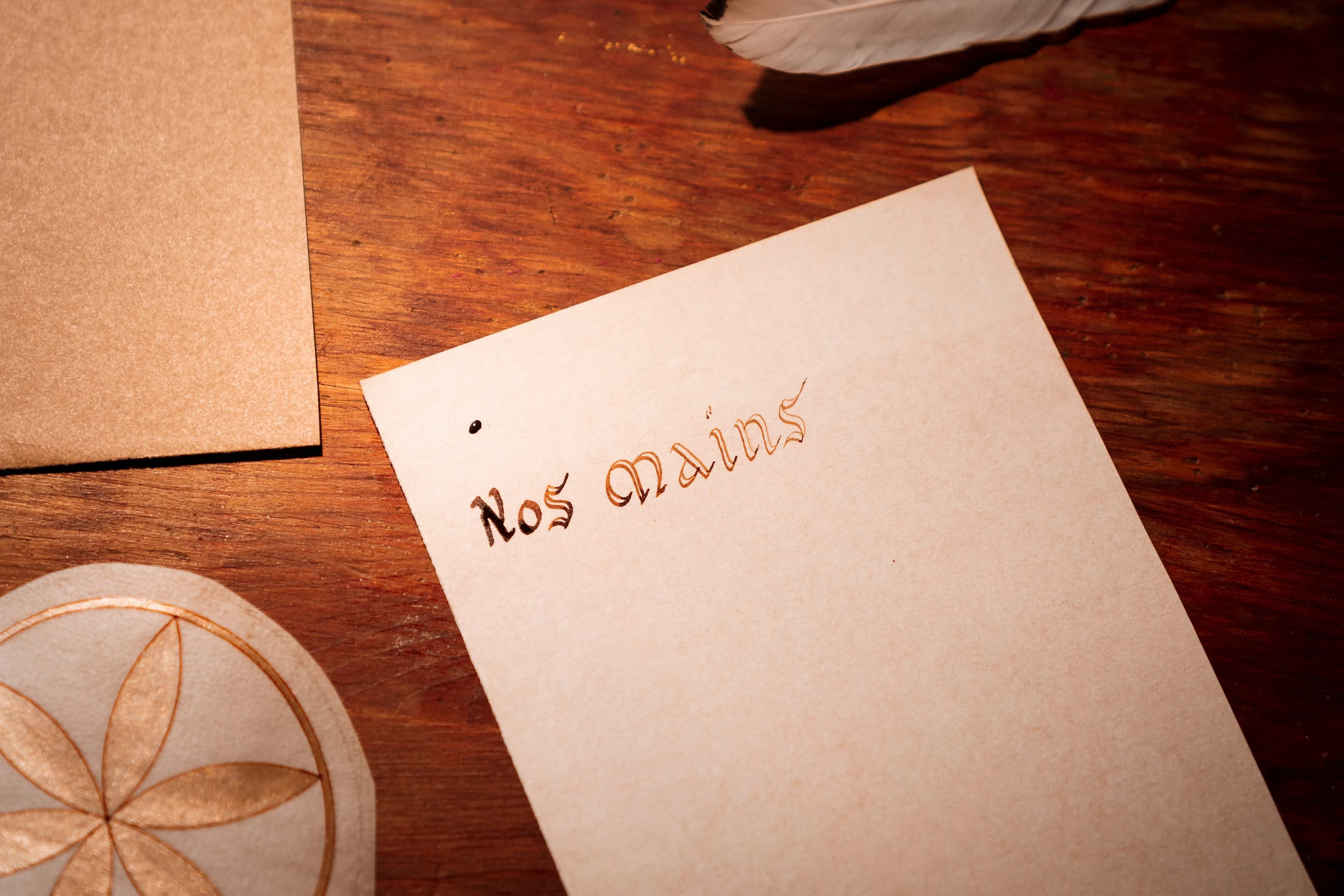 Une carte manuscrite « Nos mains » posée sur l'établi