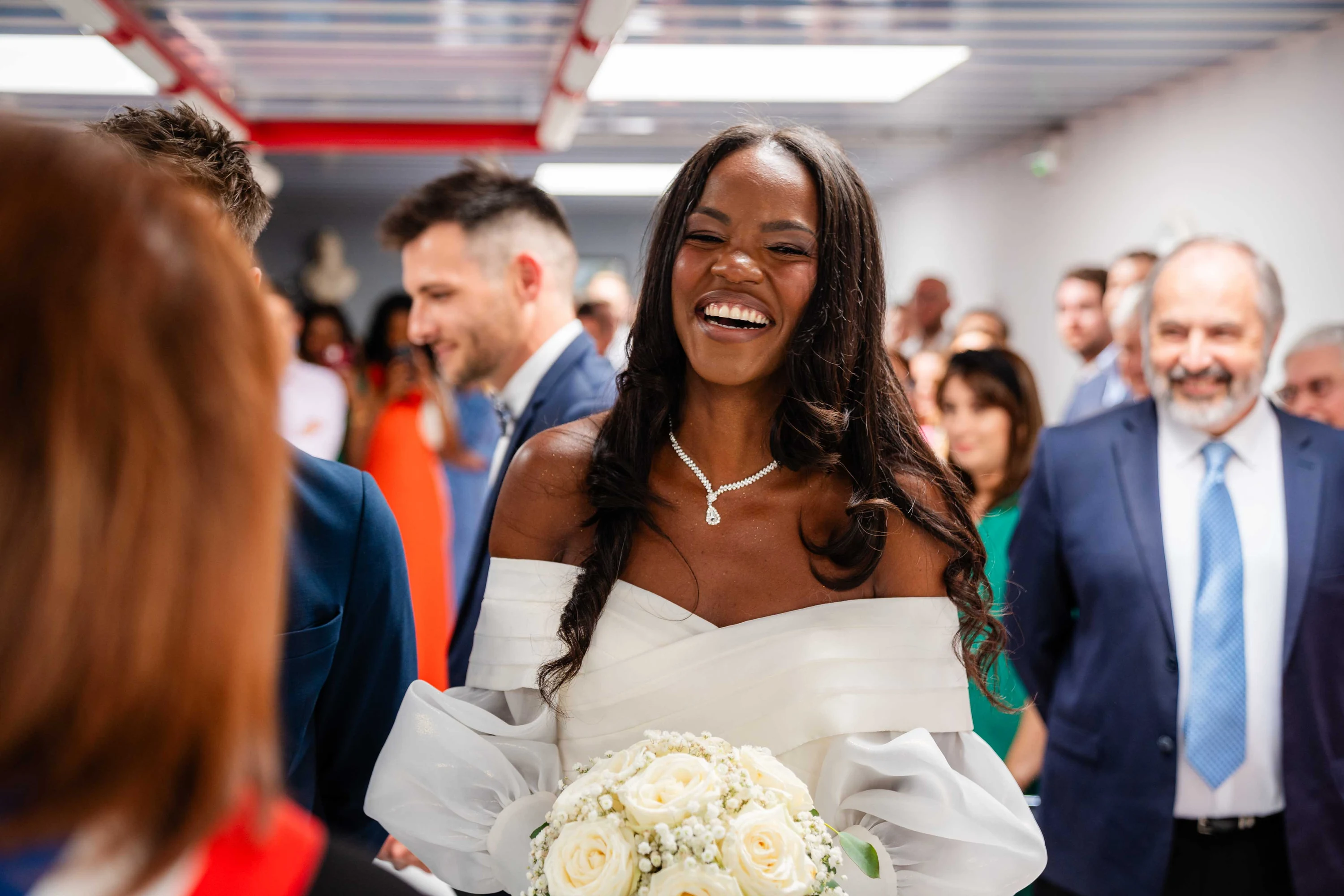 Amandine rit au milieu des invités juste avant la première cérémonie, son bouquet à la main