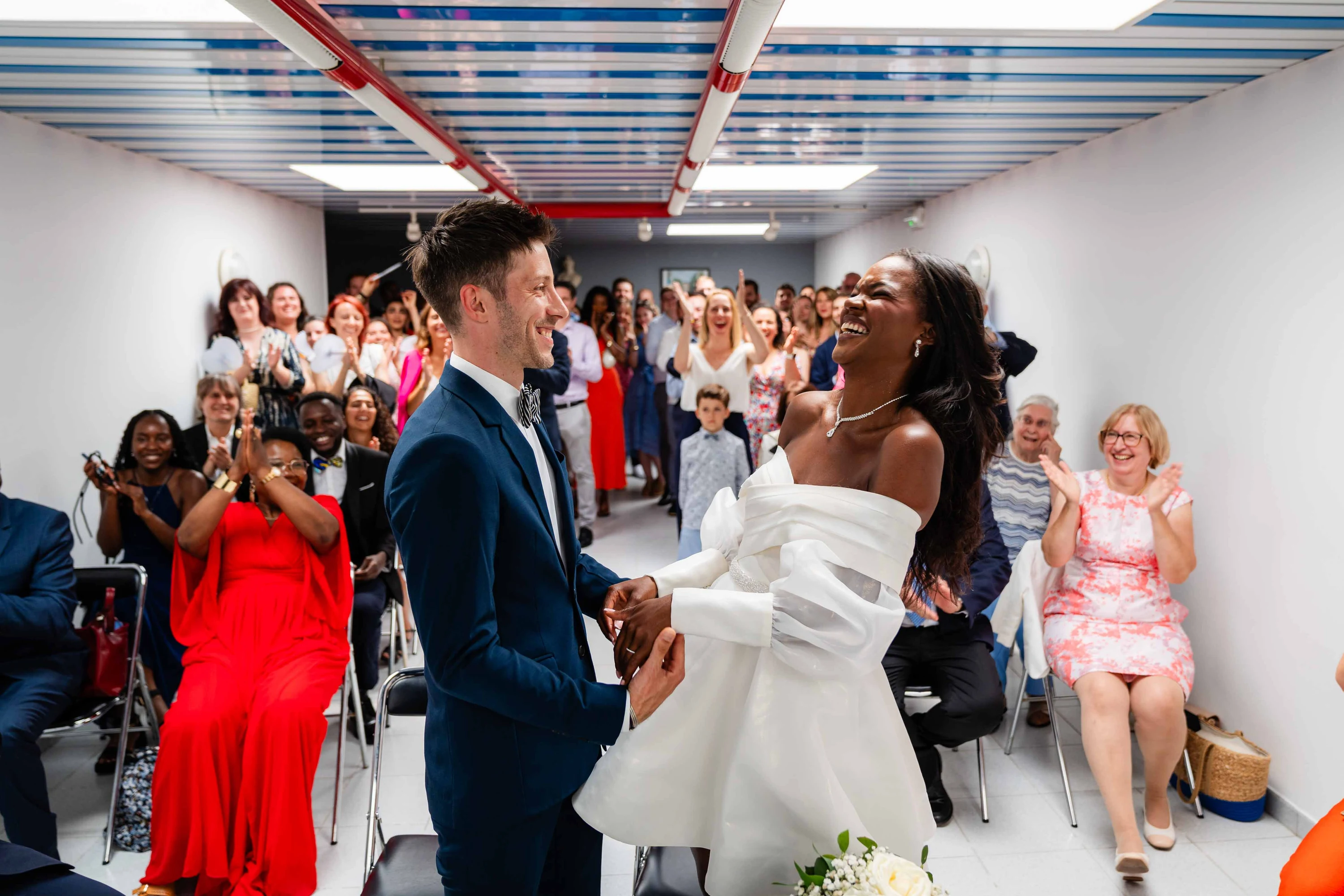 Amandine et Benjamin se font face dans l'allée pendant que les invités applaudissent