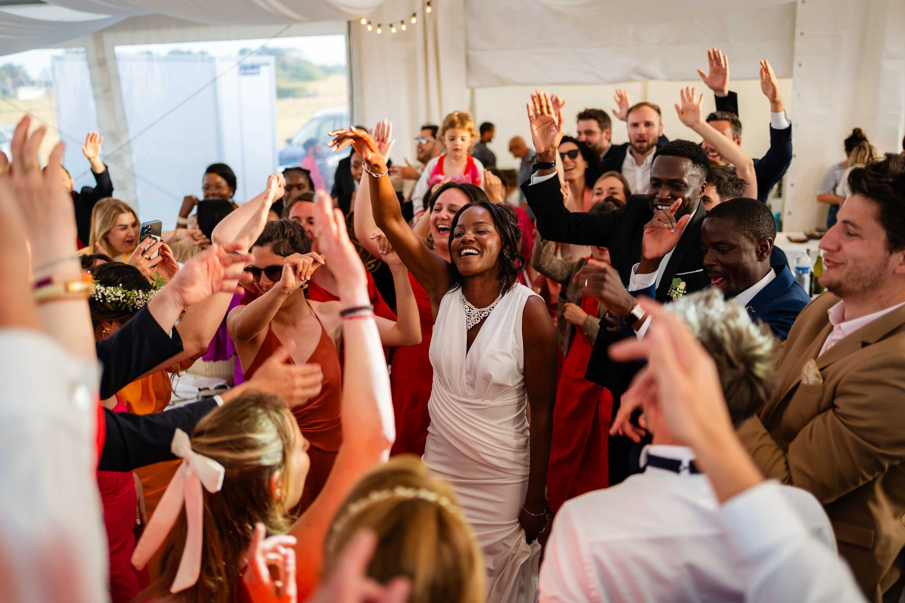 Les bras en l'air sur la piste de danse, Amandine au milieu des invités