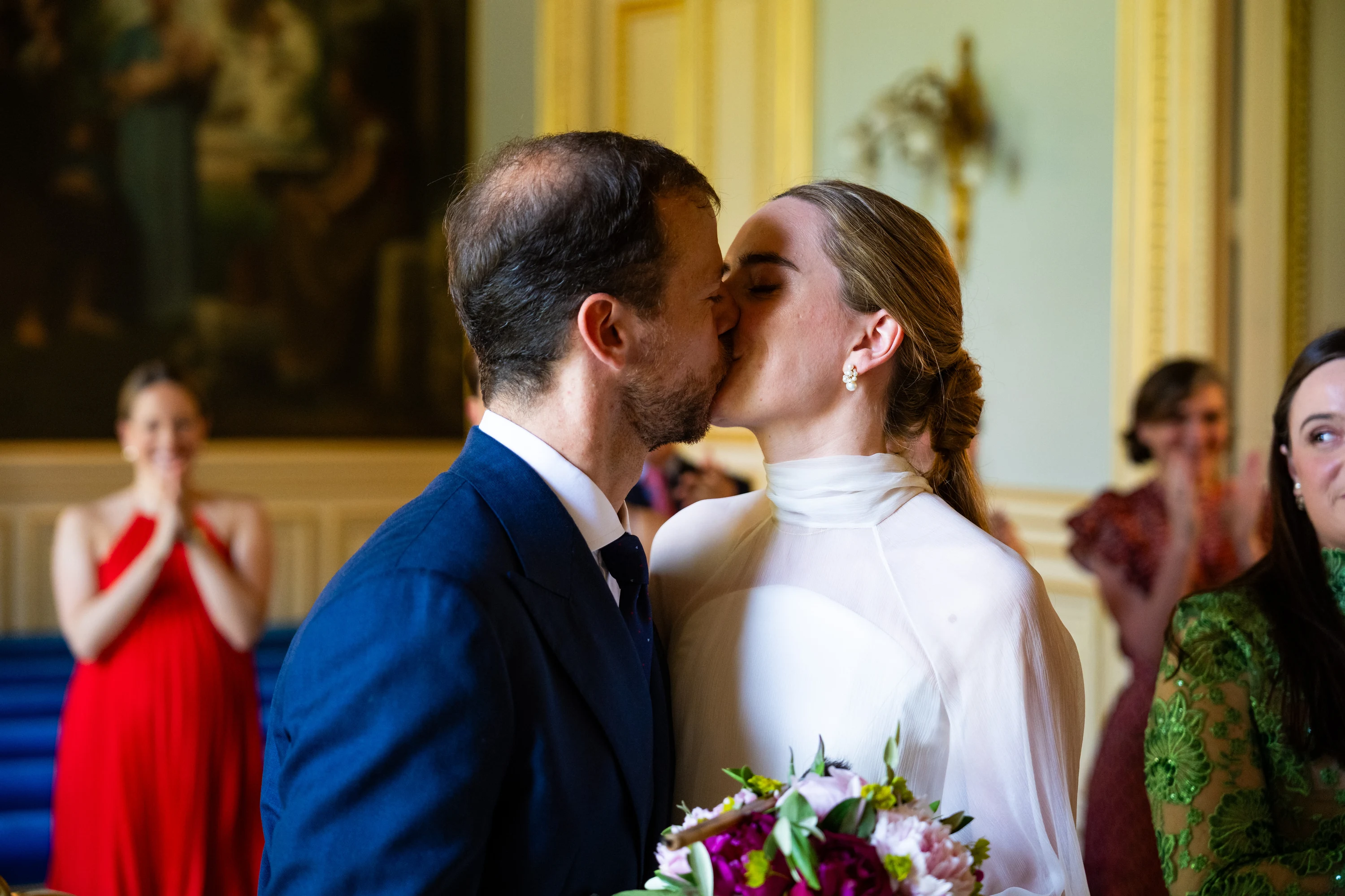 Le baiser des mariés à la mairie du 7e, entourés de leurs invités