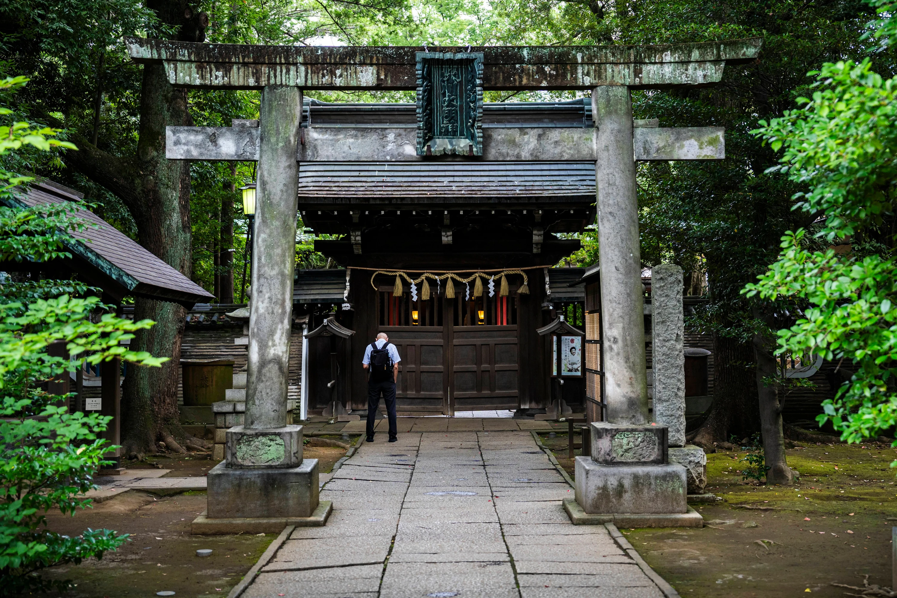 Un homme s'arrête saluer devant un sanctuaire shinto à Tokyo