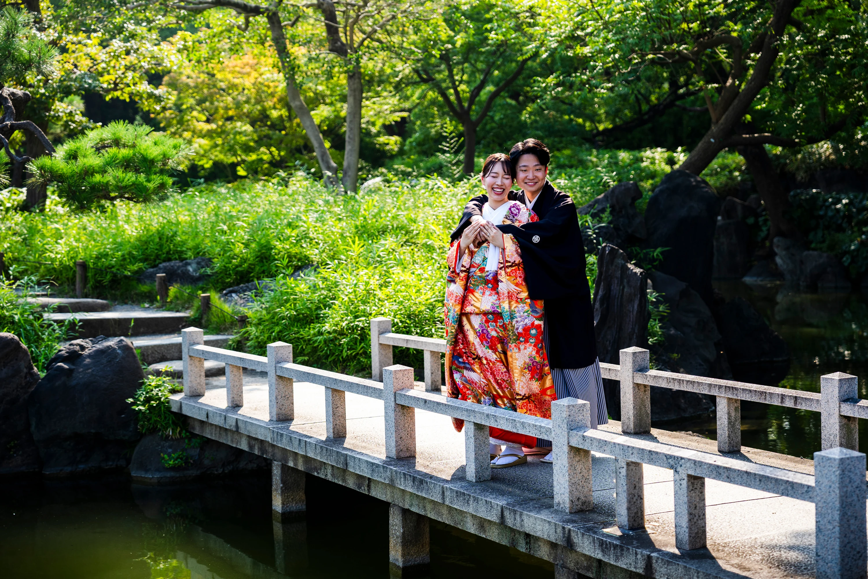 Couple en tenue traditionnelle japonaise sur un pont de jardin à Tokyo